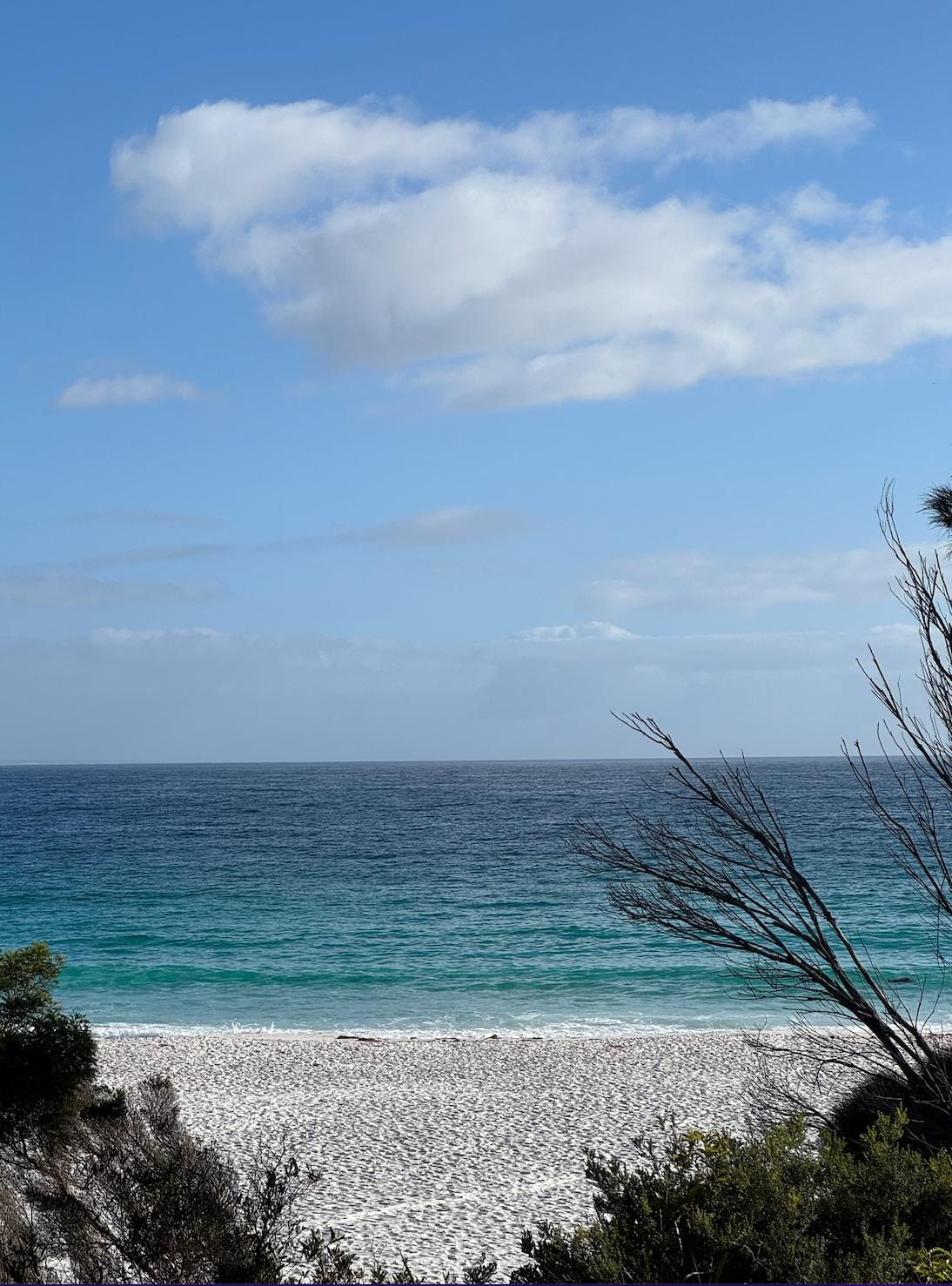 A still beach with white sand, teal water and blue sky — a place of quiet and rest